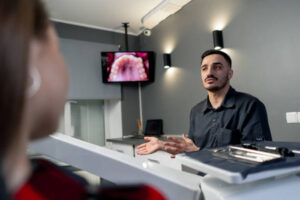 Dentist speaking with patient inside modern dental clinic comparing corporate and local practice environments