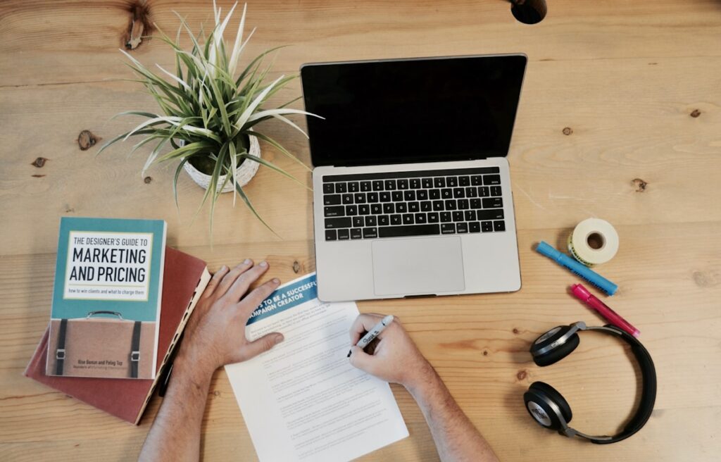 Statue of a heroic figure overloA creator's desk with a laptop, marketing guide and planning notes representing the business side of content creationoking Chicago skyline at dusk, symbolizing strength and resilience