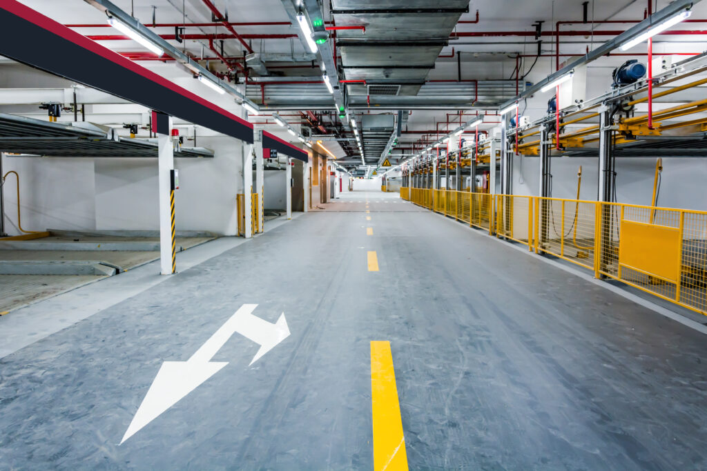 Silent underground parking garage with rows of vacant parking spaces and concrete pillars